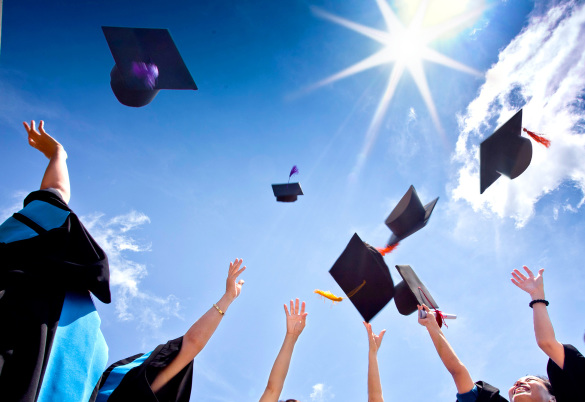 Students-with-congratulations-throwing-graduation-hats-in-the-air-celebrating
