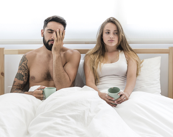 young-couple-with-cup-coffee-sitting-bed